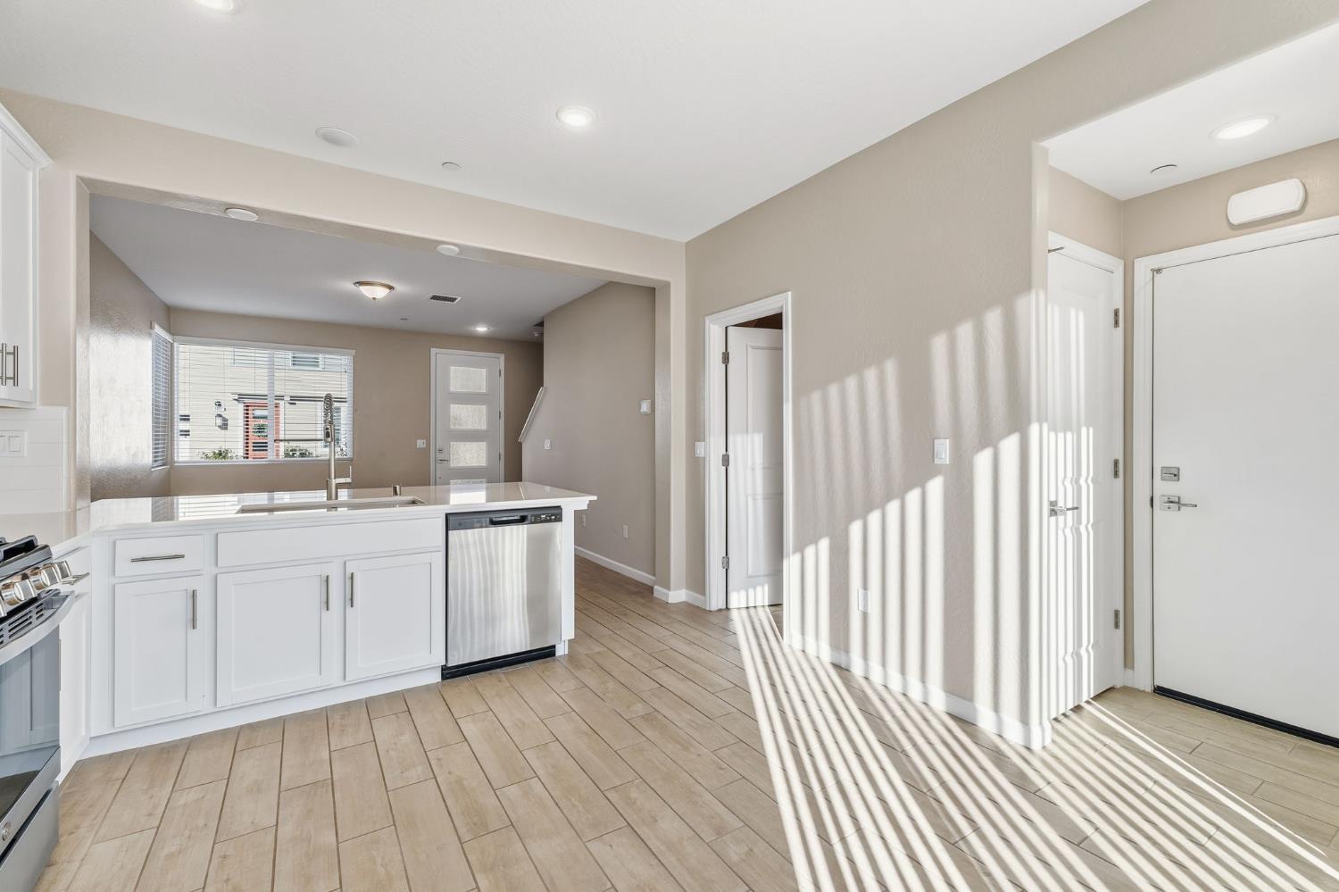 1116 Elevations Way West Madera, CA 93636 - Photo 12 of 35 a large white kitchen with a sink and dishwasher a stove with wooden floor