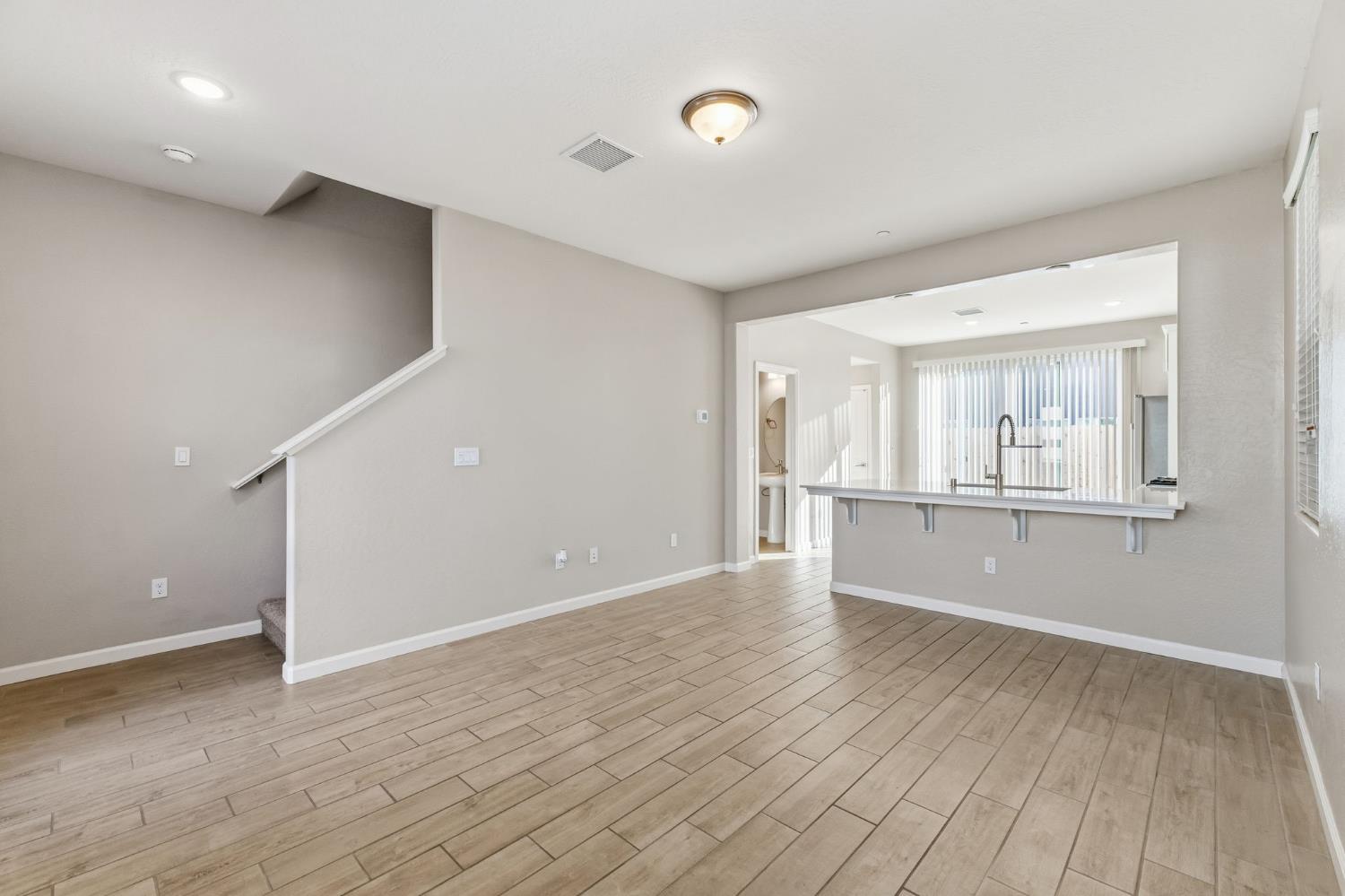 1116 Elevations Way West Madera, CA 93636 - Photo 6 of 35 a view of an empty room with wooden floor and a window