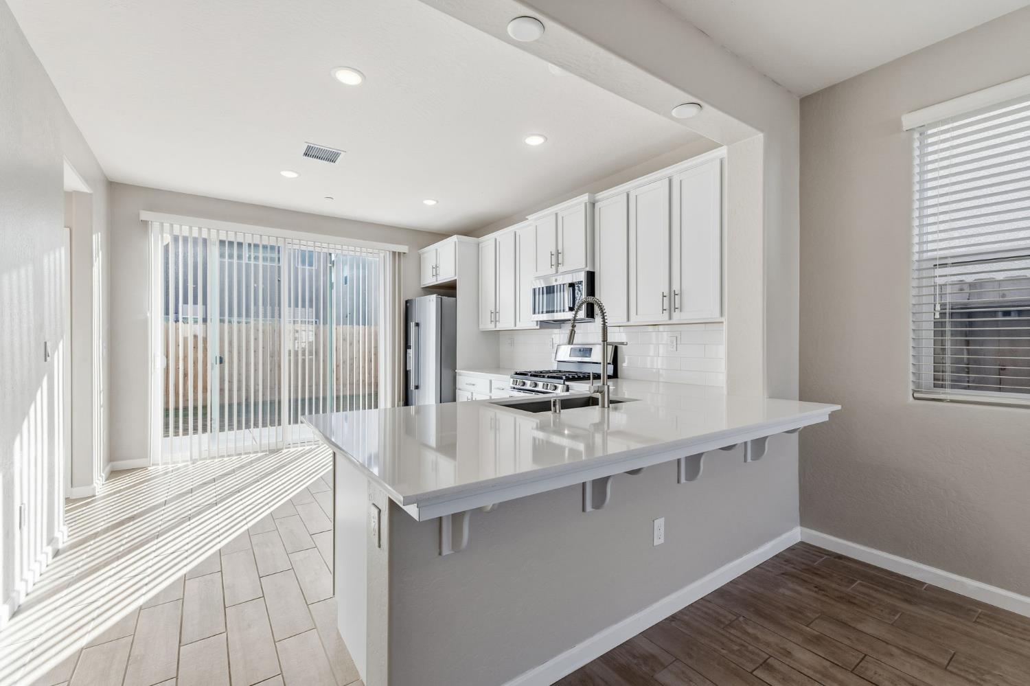 1116 Elevations Way West Madera, CA 93636 - Photo 8 of 35 a kitchen with kitchen island a sink appliances cabinets and a large window
