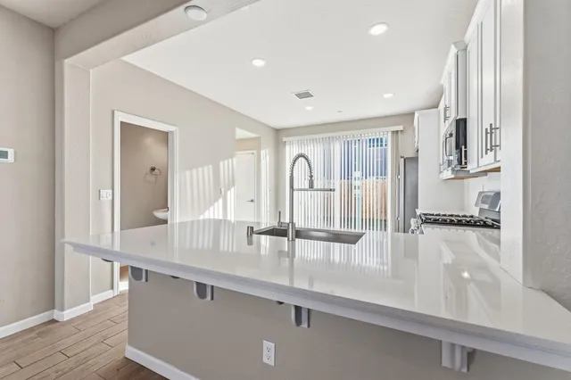 a view of a kitchen with granite countertop a sink and cabinets