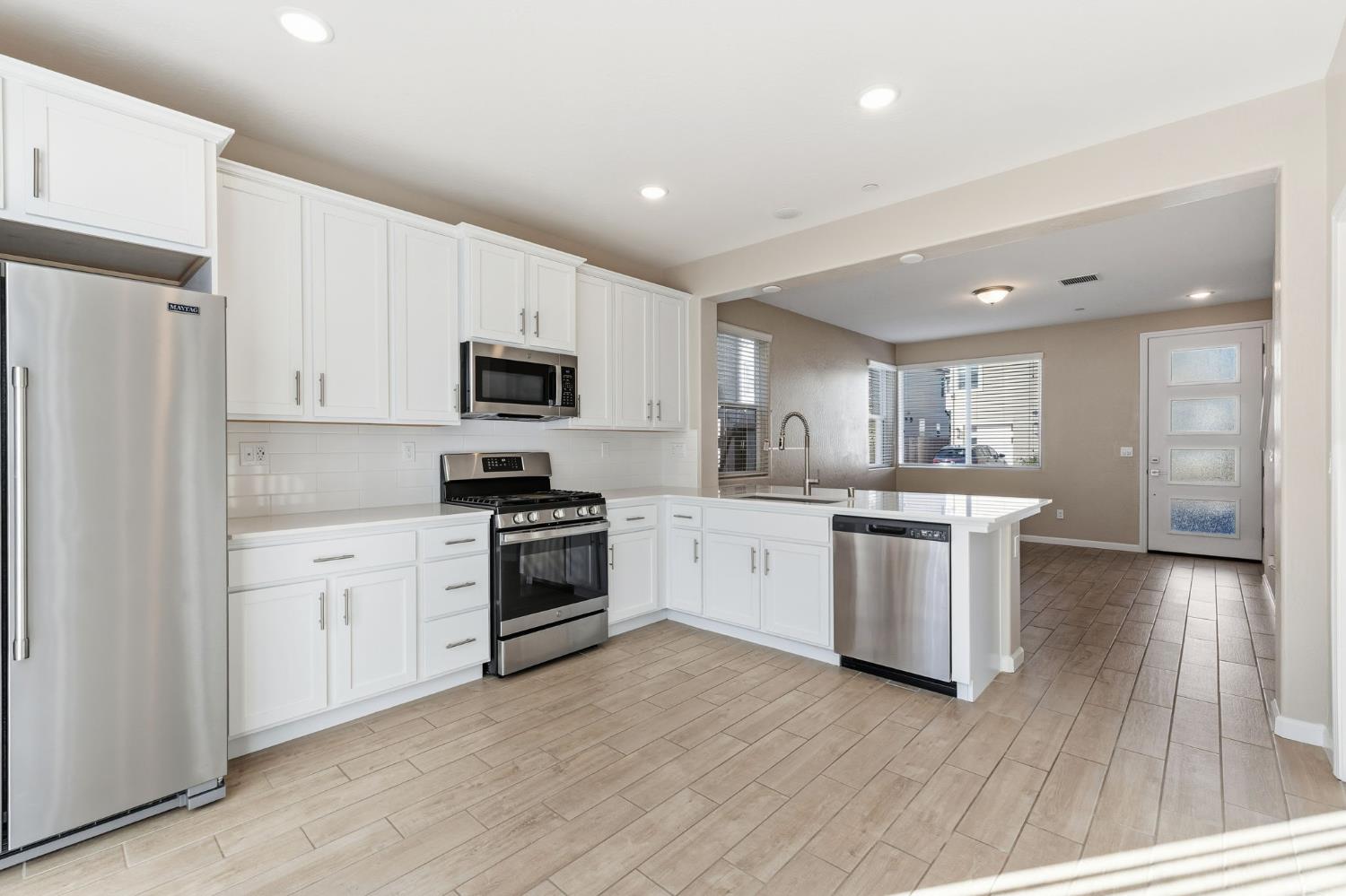 1116 Elevations Way West Madera, CA 93636 - Photo 10 of 35 a kitchen with granite countertop white cabinets and stainless steel appliances