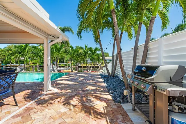 a view of a patio with table and chairs potted plants and palm trees