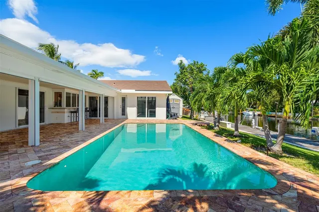 a view of a house with swimming pool and sitting area