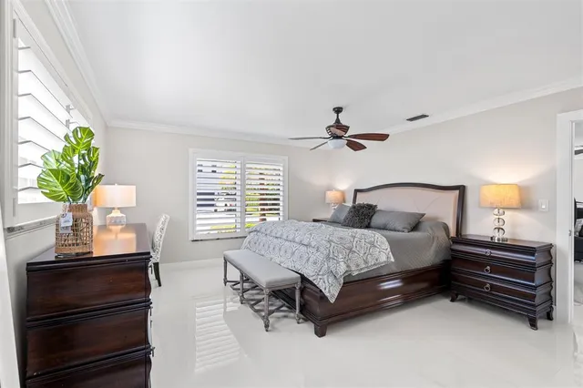 a bedroom with a bed and a potted plant on the dresser