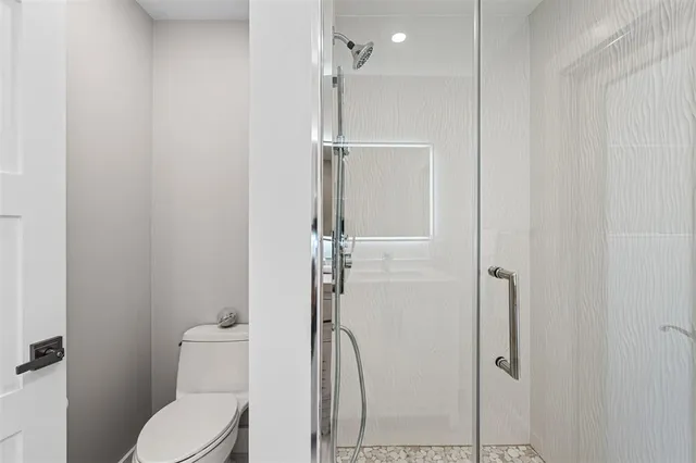 a bathroom with a toilet and a shower