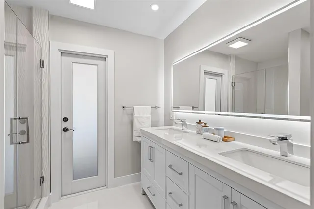 a bathroom with double vanity sinks and a mirror