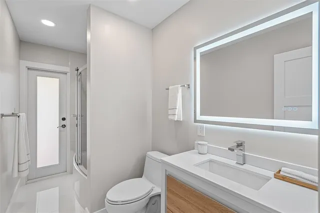 a bathroom with a granite countertop sink toilet a mirror and shower