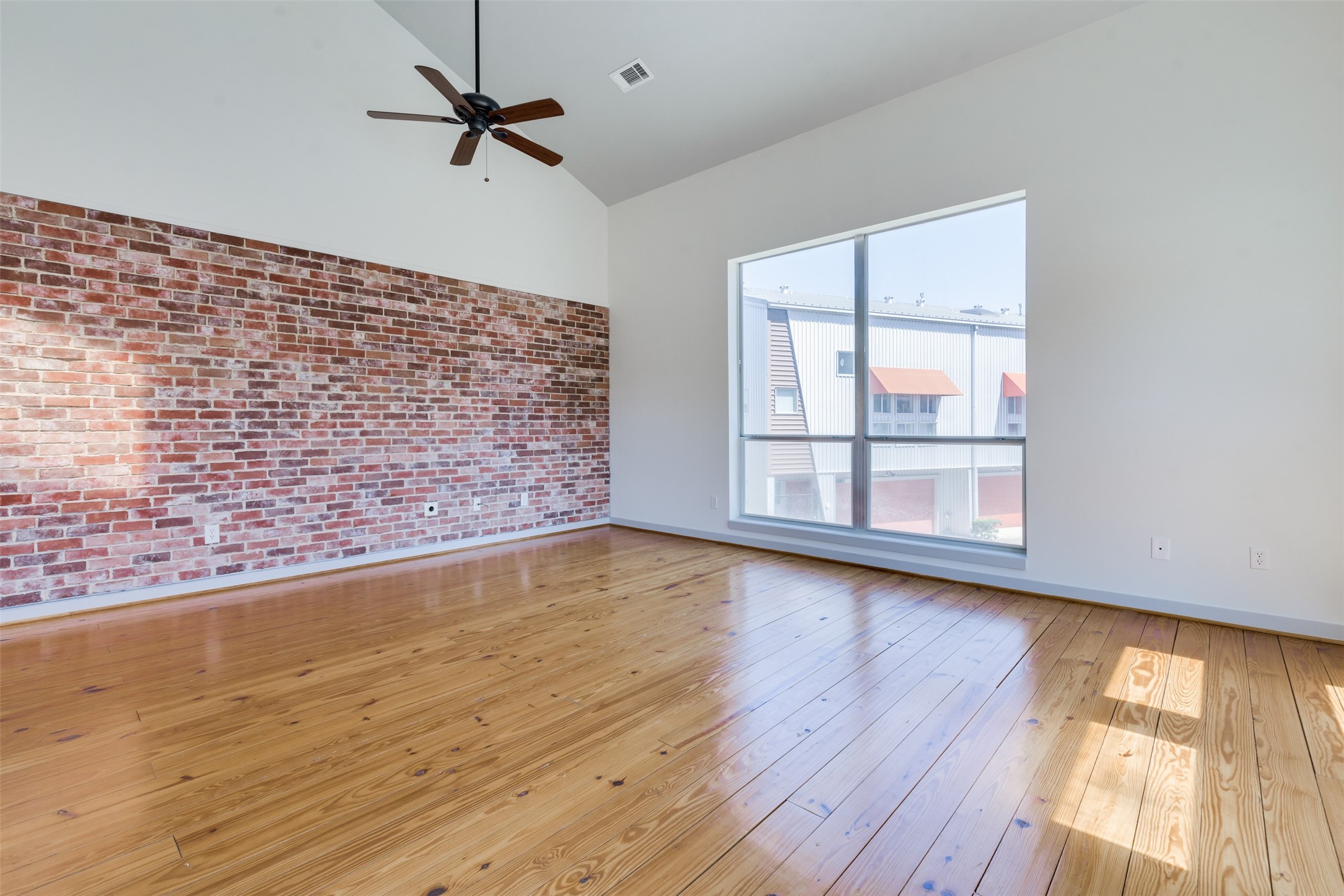2605 Calumet Street, Unit 48 Houston, TX 77004 - Photo 26 of 34 an empty room with wooden floor fan and windows