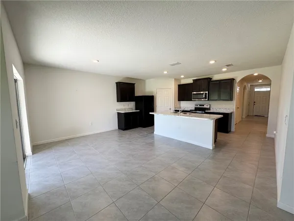 a large kitchen with a stove a sink and a microwave