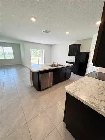 a large kitchen with kitchen island a sink stainless steel appliances and cabinets