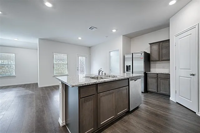 a kitchen with stainless steel appliances granite countertop a sink stove and refrigerator