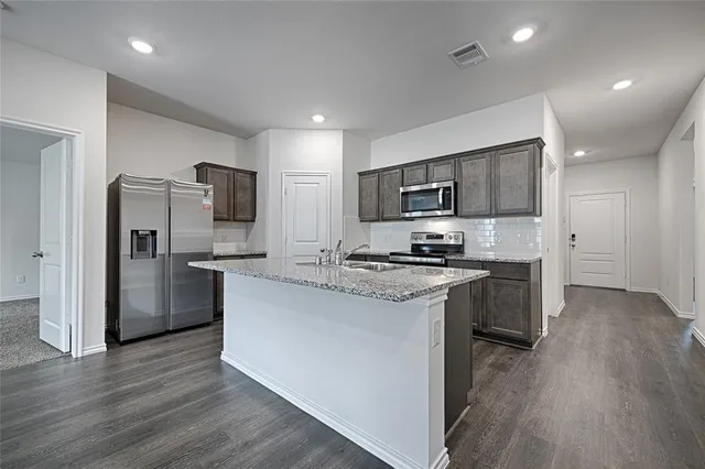 a kitchen with kitchen island a refrigerator stove and microwave