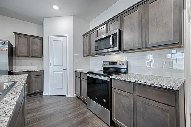 a view of a kitchen island a sink wooden floor and living room
