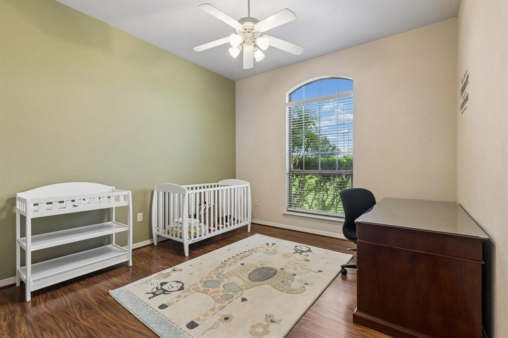 317 Singing Quail Trail Haslet, TX 76052 - Photo 20 of 32 Room featuring wood-finish flooring, an arched window with blinds, a ceiling fan with integrated lighting, and a neutral wall palette
