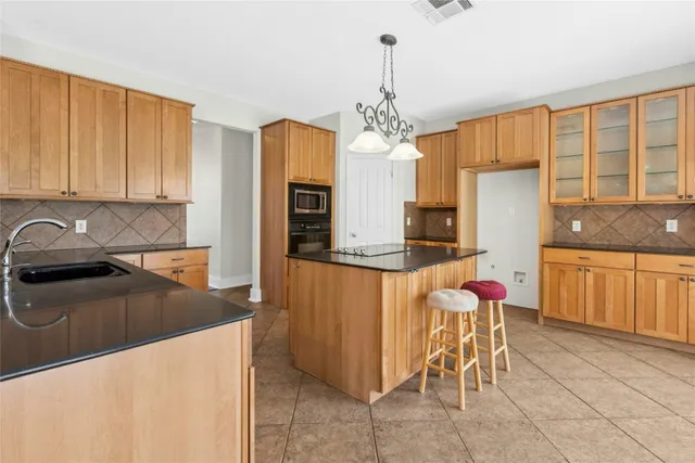 a kitchen with stainless steel appliances granite countertop a sink and a refrigerator