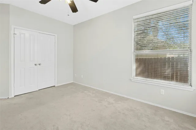 a view of a livingroom with a window and a ceiling fan