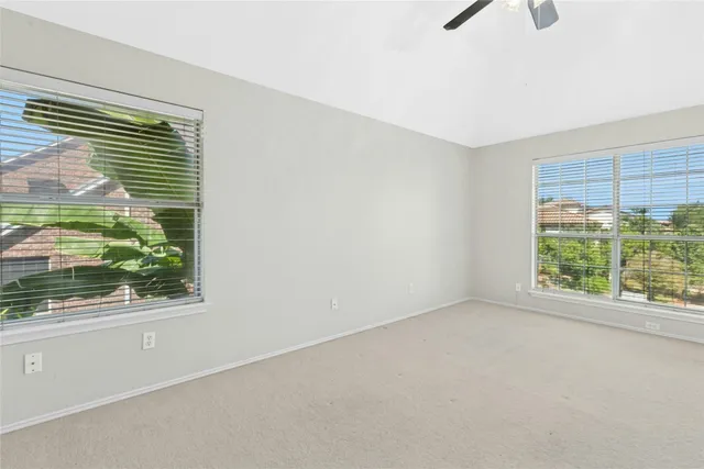 a view of a livingroom with a chandelier fan and windows