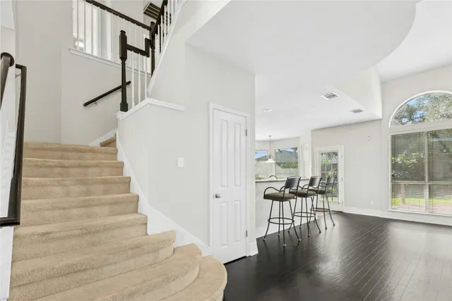 a view of a livingroom with wooden floor and a hallway