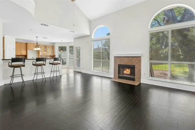 an empty room with windows and fireplace