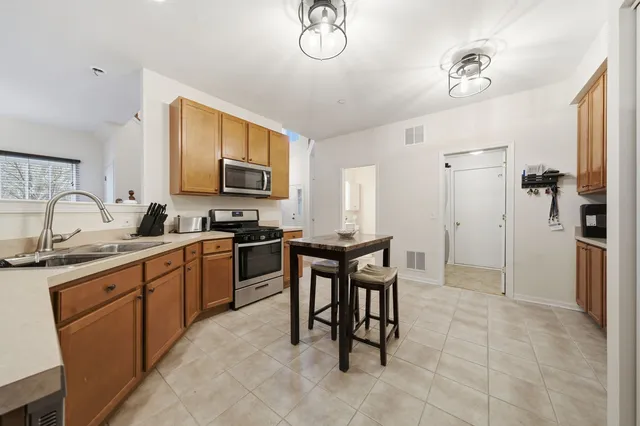 a kitchen with granite countertop a sink stainless steel appliances and cabinets