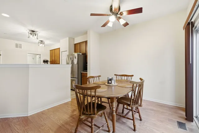 a view of a dining room with furniture and a chandelier fan