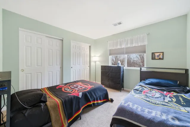 a spacious bedroom with a bed and a chair