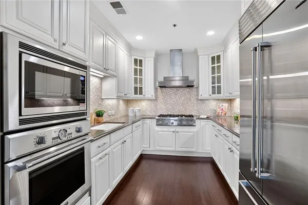 a kitchen with stainless steel appliances granite countertop cabinets and microwave