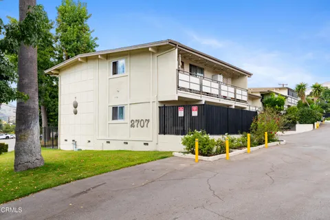 a view of an house with backyard and bushes