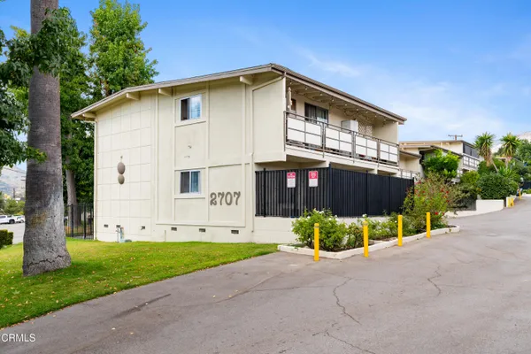 a view of an house with backyard and bushes
