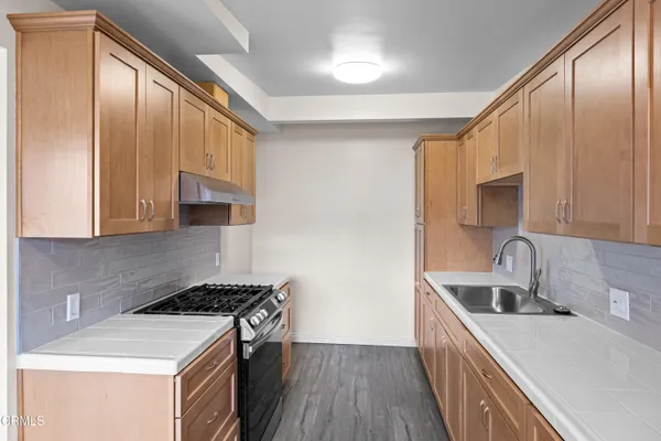 a kitchen that has a sink and a stove in it