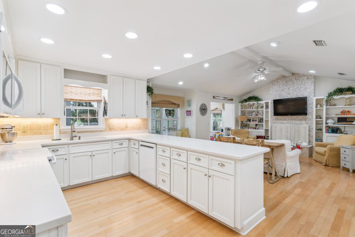 311 Dunbarton Drive St. Simons, GA 31522 - Photo 13 of 44 a large white kitchen with a large window and white cabinets