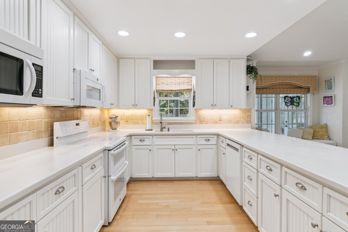 311 Dunbarton Drive St. Simons, GA 31522 - Photo 14 of 44 a kitchen with granite countertop white cabinets white stainless steel appliances with a sink and dishwasher