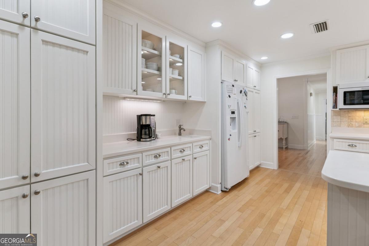 311 Dunbarton Drive St. Simons, GA 31522 - Photo 15 of 44 a kitchen with white cabinets and refrigerator