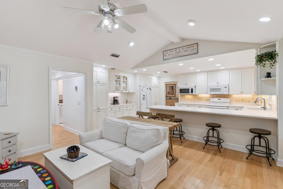 311 Dunbarton Drive St. Simons, GA 31522 - Photo 18 of 44 a kitchen with stainless steel appliances kitchen island a white table chairs and a refrigerator