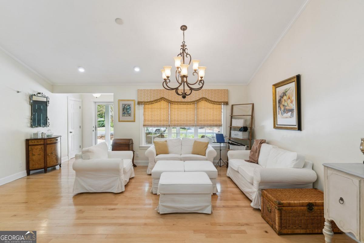 311 Dunbarton Drive St. Simons, GA 31522 - Photo 19 of 44 a living room with furniture a fireplace and a chandelier
