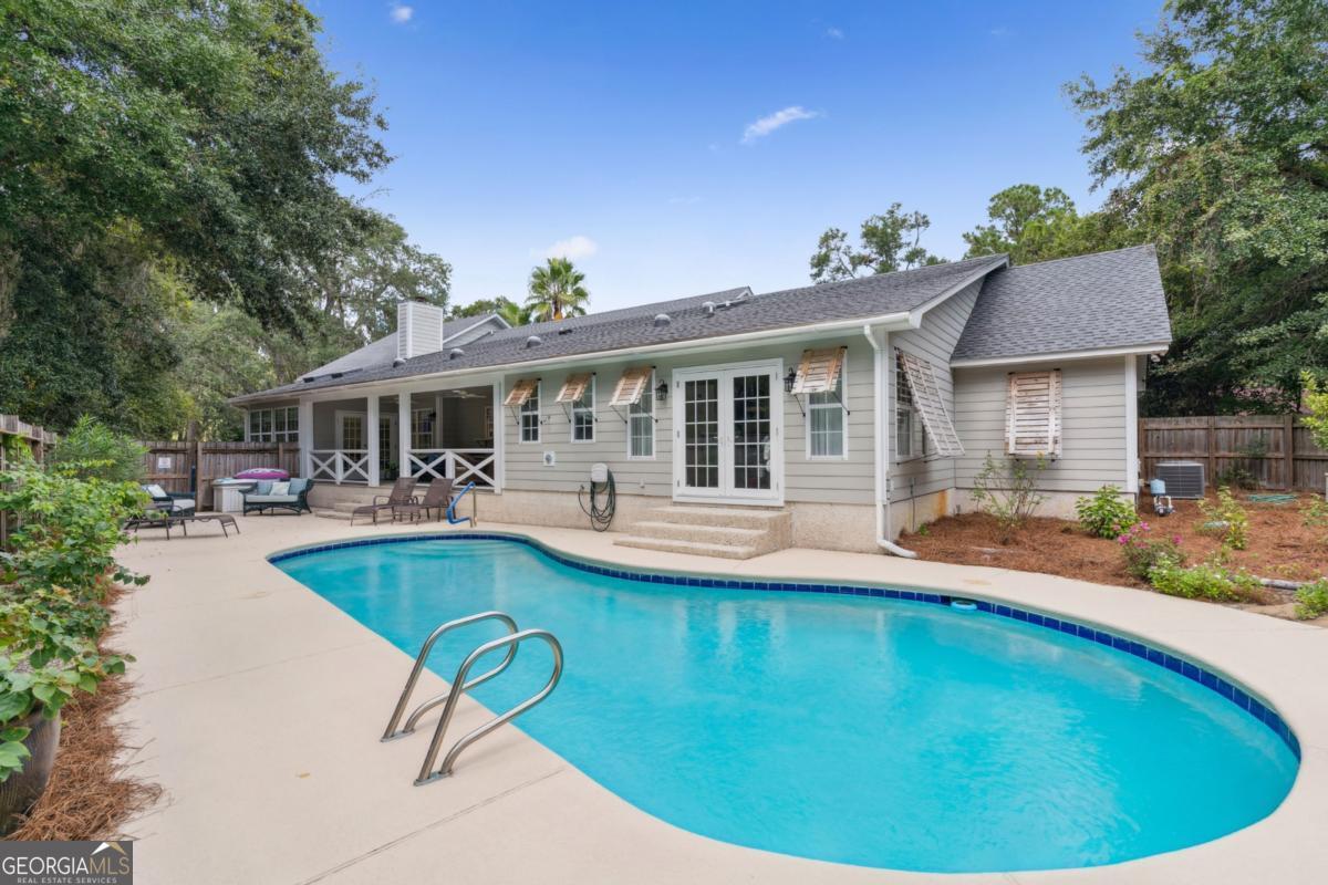 311 Dunbarton Drive St. Simons, GA 31522 - Photo 2 of 44 a view of a house with swimming pool and porch