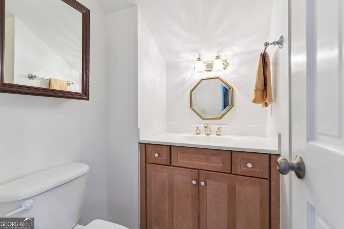 311 Dunbarton Drive St. Simons, GA 31522 - Photo 39 of 44 a bathroom with a toilet sink vanity and mirror