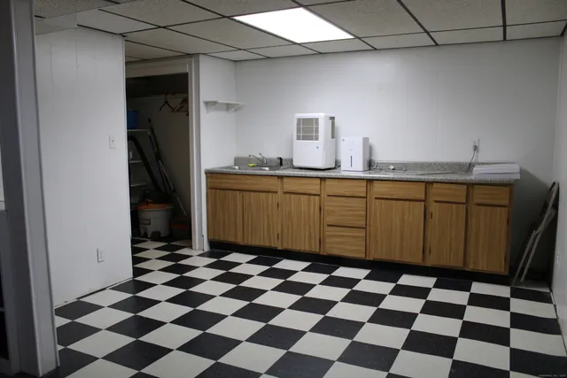 a kitchen with a checkered floor and white cabinets