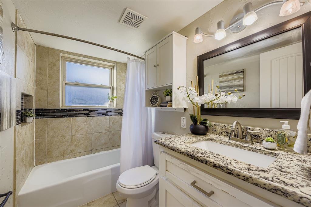 2801 Fairbrook Street Irving, TX 75062 - Photo 19 of 23 a bathroom with a granite countertop sink toilet mirror vanity and bathtub