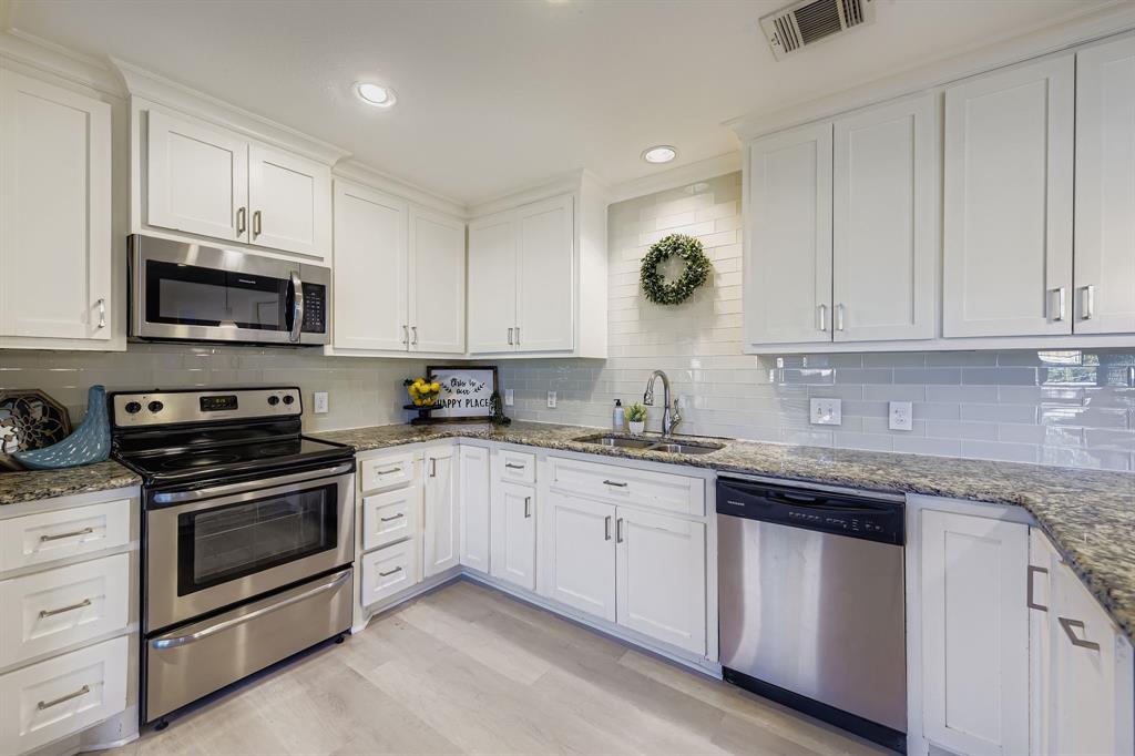 2801 Fairbrook Street Irving, TX 75062 - Photo 10 of 23 a kitchen with granite countertop white cabinets white stainless steel appliances and sink