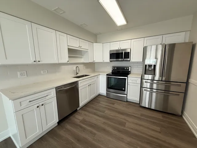 a kitchen with cabinets stainless steel appliances and a window