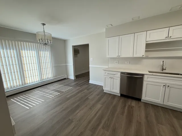 a kitchen that has a lot of cabinets stainless steel appliances and a counter space