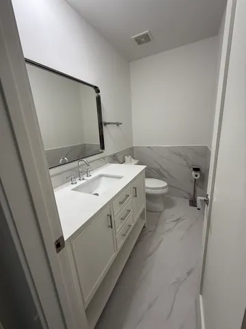 a bathroom with a sink a toilet and mirror