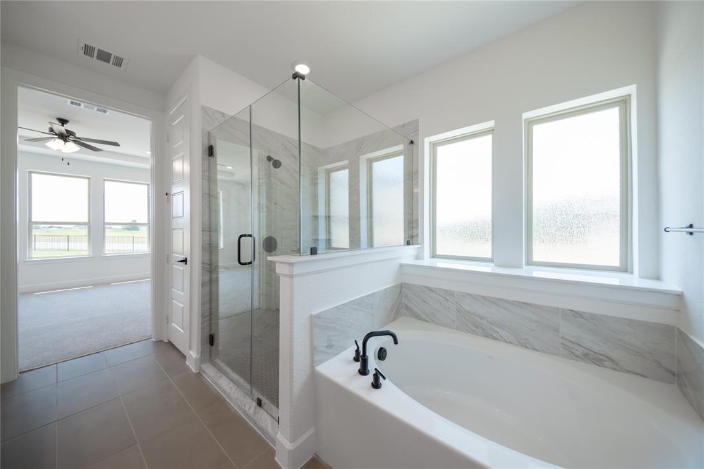 2719 Triumph Court Heath, TX 75126 - Photo 26 of 39 a bathroom with a bathtub and a shower