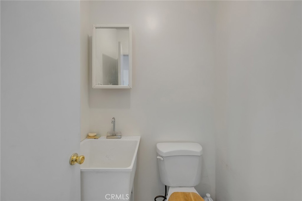 12736 Oasis Road Pinon Hills, CA 92372 - Photo 23 of 33 a bathroom with a toilet a sink and mirror