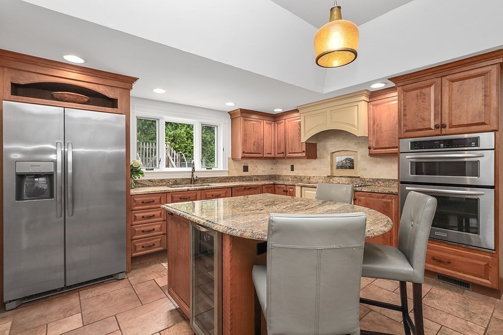 20 Maple Avenue Upton, MA 01568 - Photo 7 of 42 a kitchen with stainless steel appliances granite countertop a sink a stove a refrigerator cabinets and a dining table with wooden floor