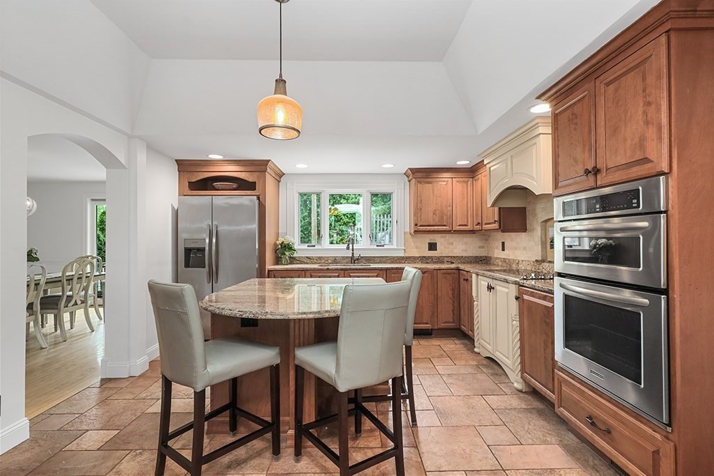 20 Maple Avenue Upton, MA 01568 - Photo 9 of 42 a kitchen with stainless steel appliances granite countertop a stove a sink dishwasher a refrigerator with a dining table and chairs with wooden floor