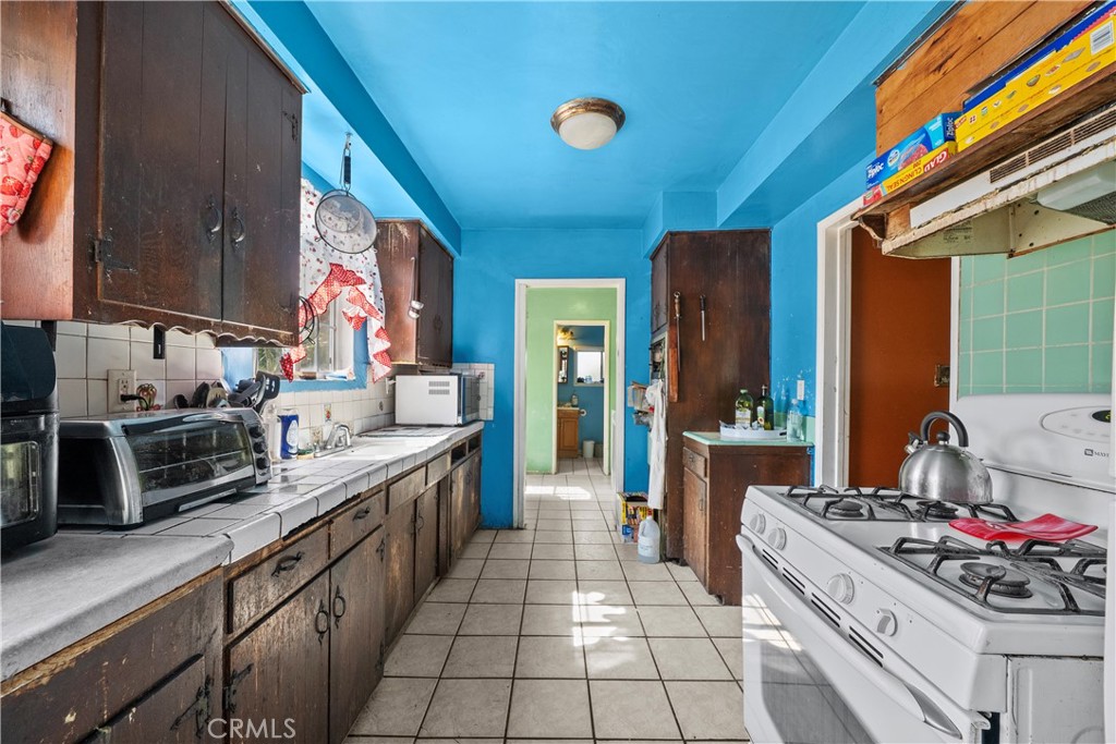 14930 Hubbard Street Sylmar, CA 91342 - Photo 10 of 22 a kitchen with stainless steel appliances a stove a sink and a refrigerator