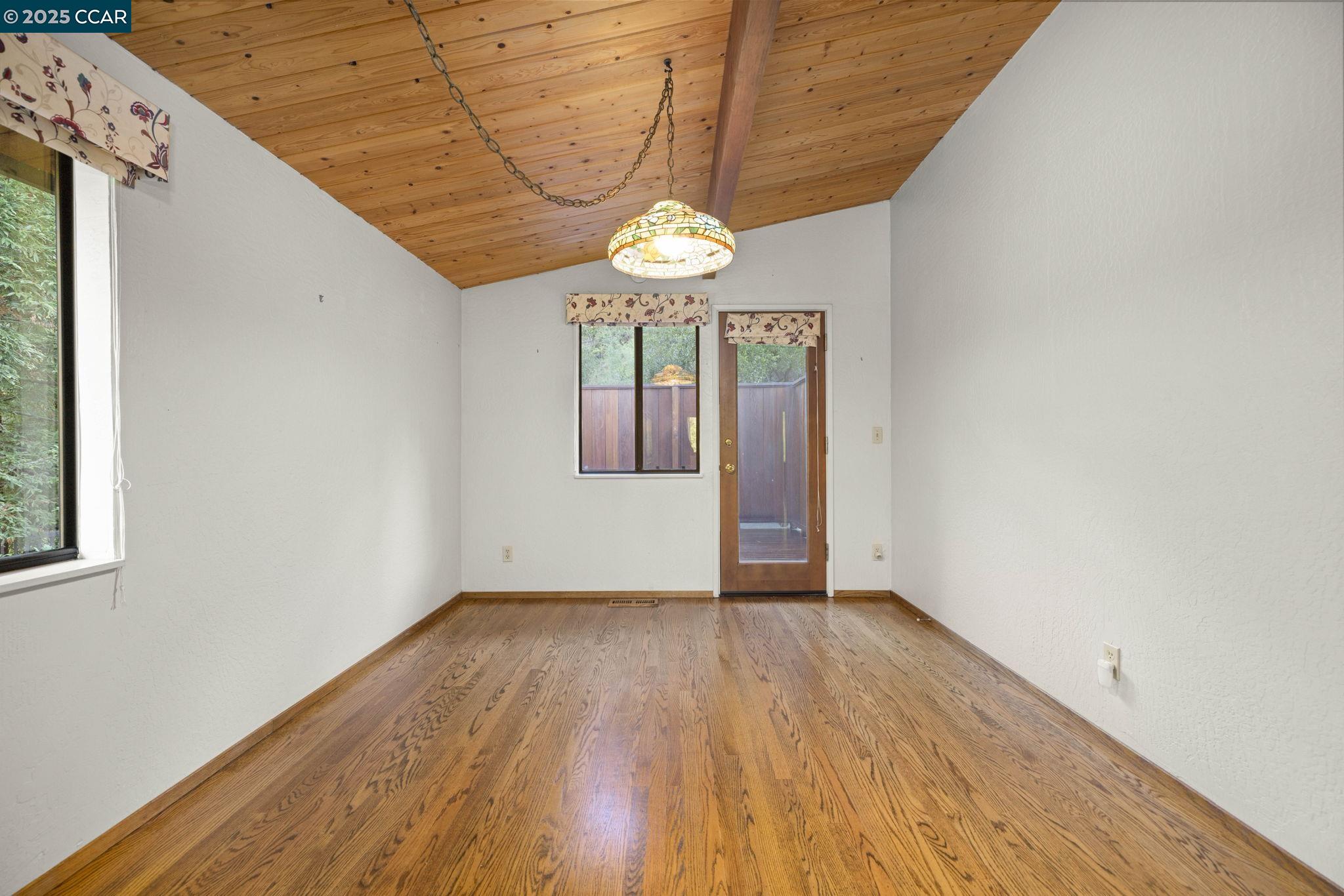 1383 Alvarado Road Berkeley, CA 94705 - Photo 13 of 47 a view of an empty room with wooden floor and a window
