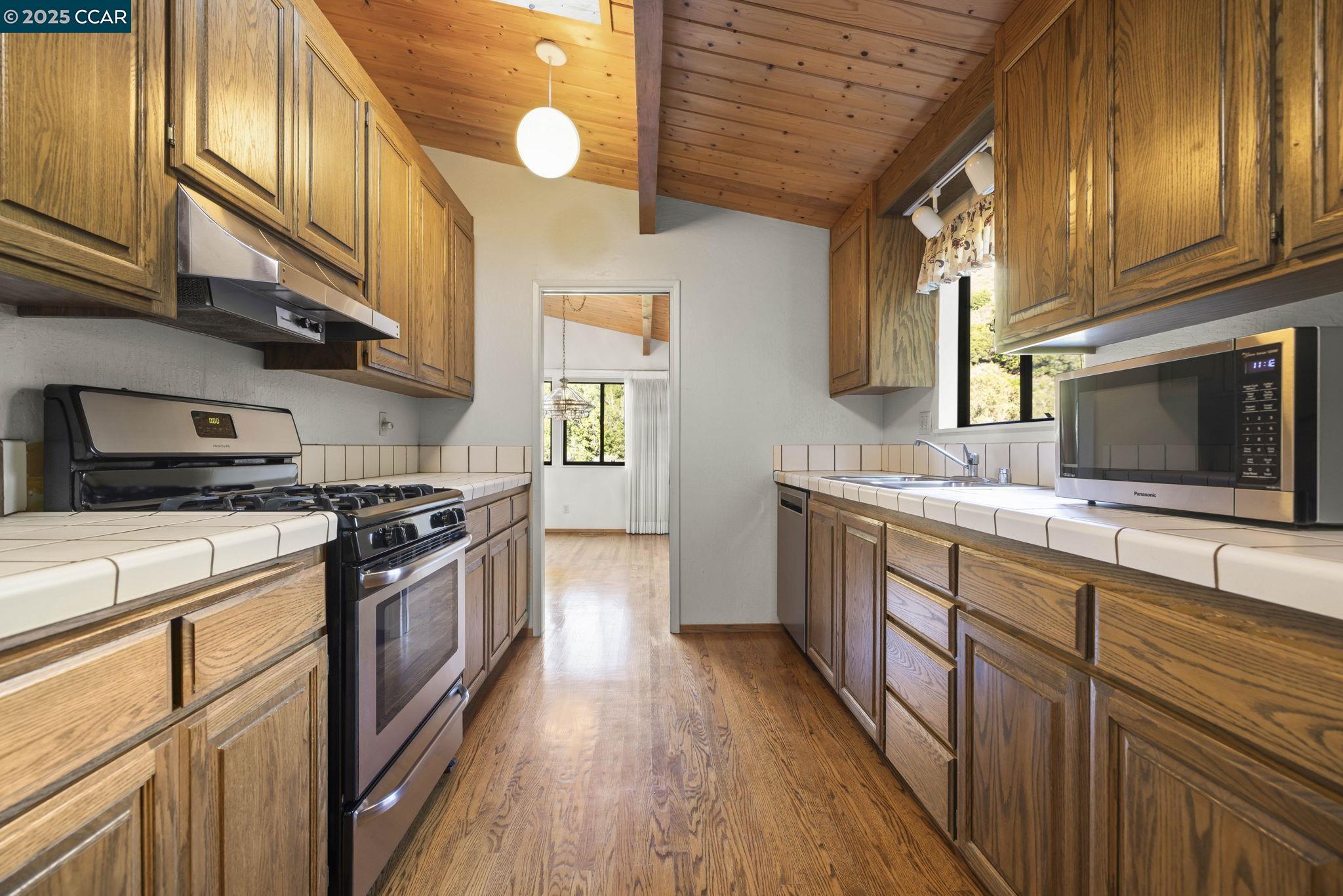 1383 Alvarado Road Berkeley, CA 94705 - Photo 16 of 47 a kitchen with stainless steel appliances granite countertop wooden cabinets a stove top oven a sink and dishwasher